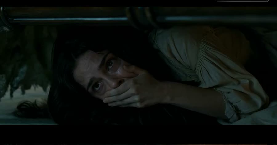 Frightened figure hiding in a dim room